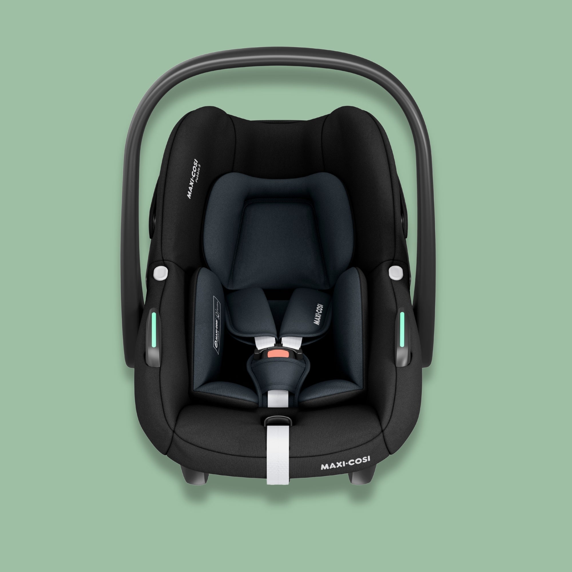 Front view of a black Maxi-Cosi Pebble S baby car seat with white harness straps on a soft green background.