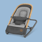 A relaxing Maxi-Cosi UAE Kori Rocker baby rocker in black and grey on a blue background.