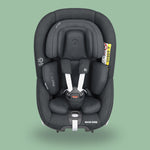 A black Maxi-Cosi Pearl 360 rotating car seat with a grey background.