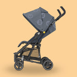 Maxi-Cosi Mara baby stroller with canopy on a pastel yellow background.