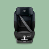 Black Maxi-Cosi car seat on a green background.